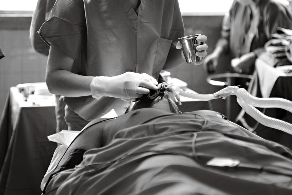 Patient applying antibiotic eye drops during corneal transplant recovery