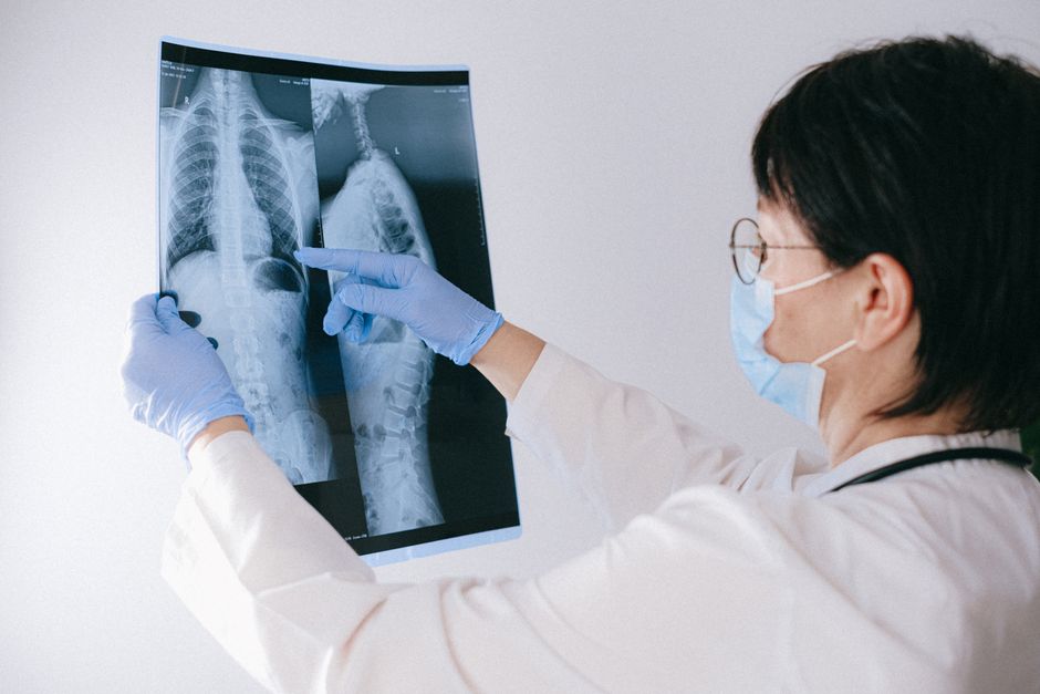 Korean spine surgeon reviewing lumbar MRI with patient before open microdiscectomy consultation