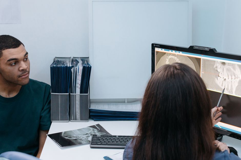Oral and maxillofacial surgery consultation in South Korea — patient reviewing jaw X-ray with specialist