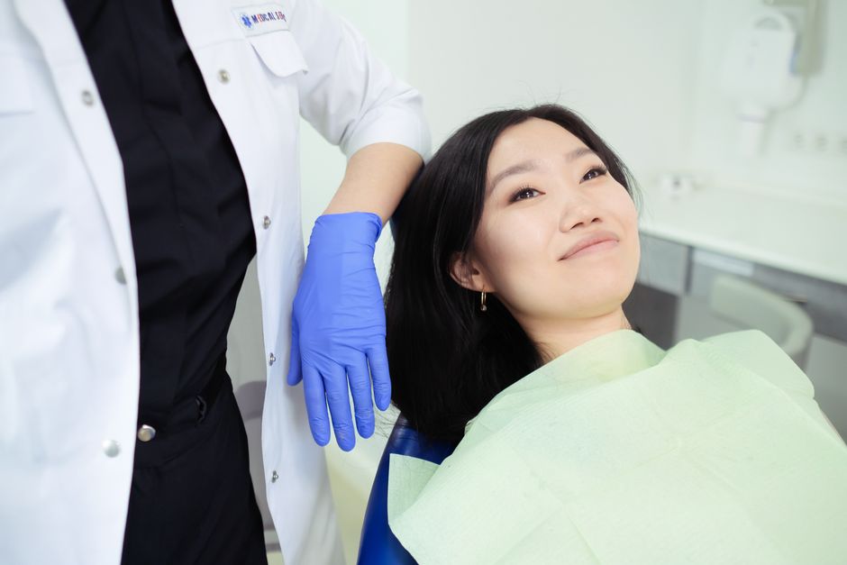 Periodontist performing gum examination during periodontal consultation in a modern Korean dental clinic