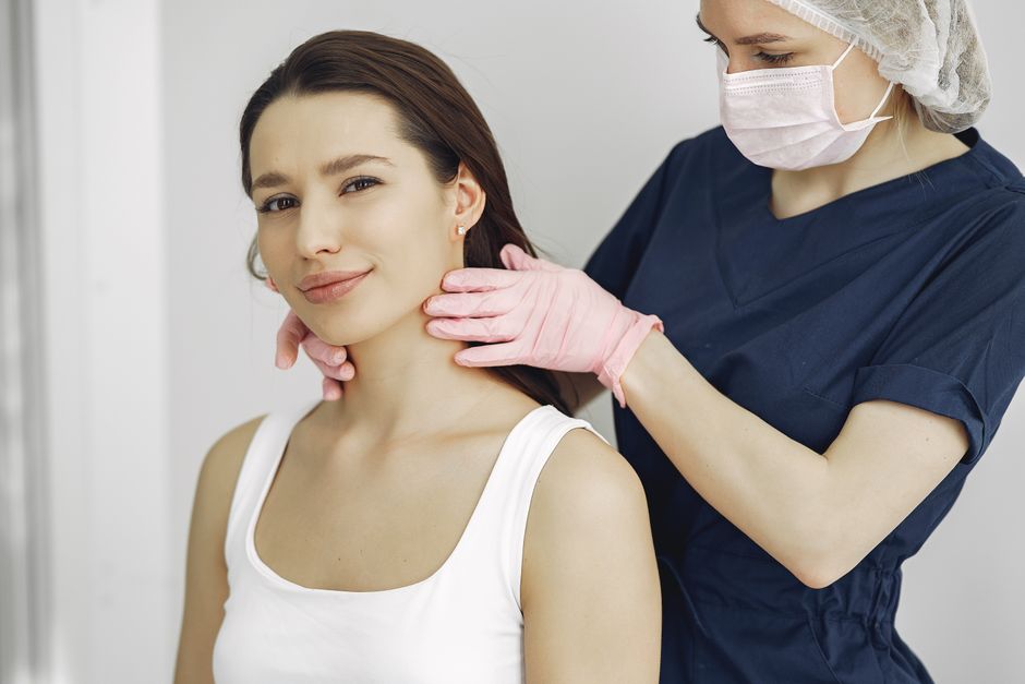 Surgeon examining a patient's neck during a thyroid surgery consultation in Korea